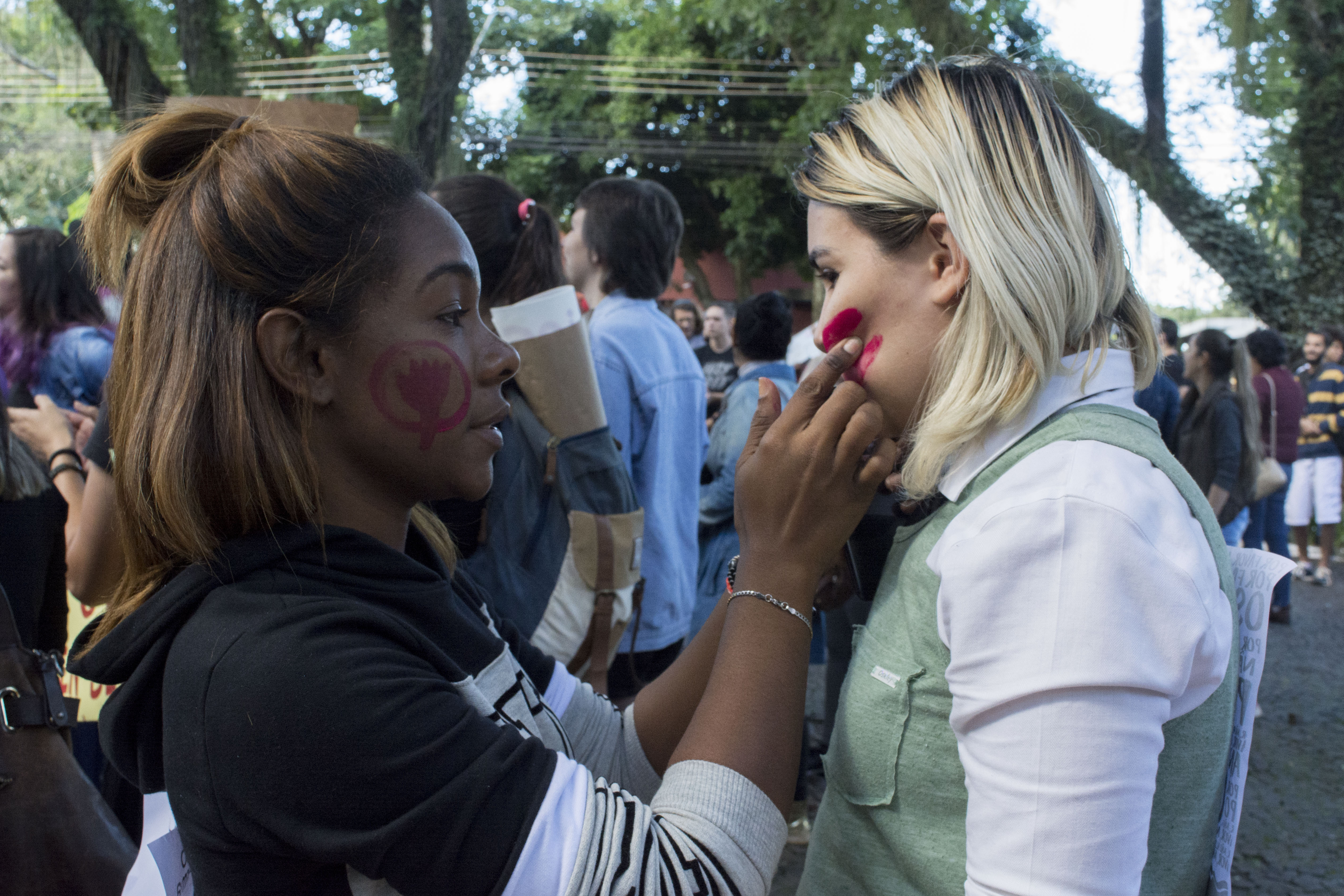 Duas jovens pintam o rosto para a manifestação